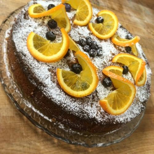 The almond and orange vegan cake that we will make make in class, decorated with slices of orange interspersed with fresh blueberries